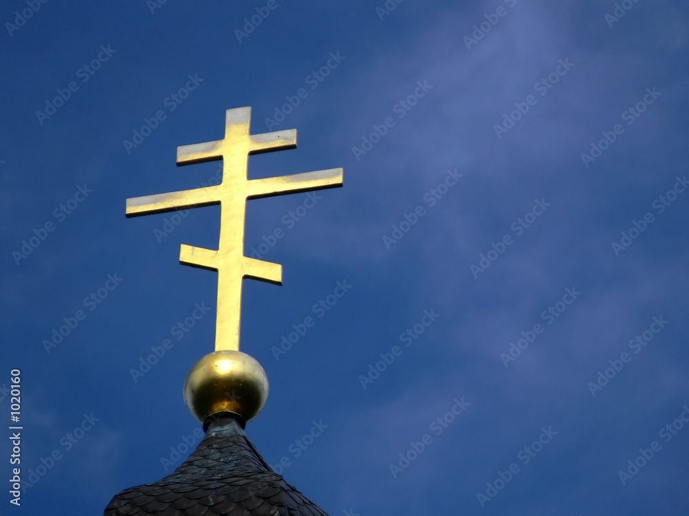 golden orthodox cross on blue sky