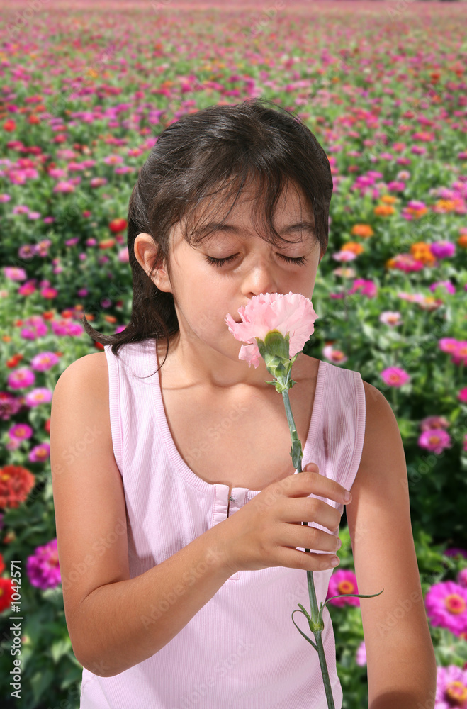 young girl smelling flower