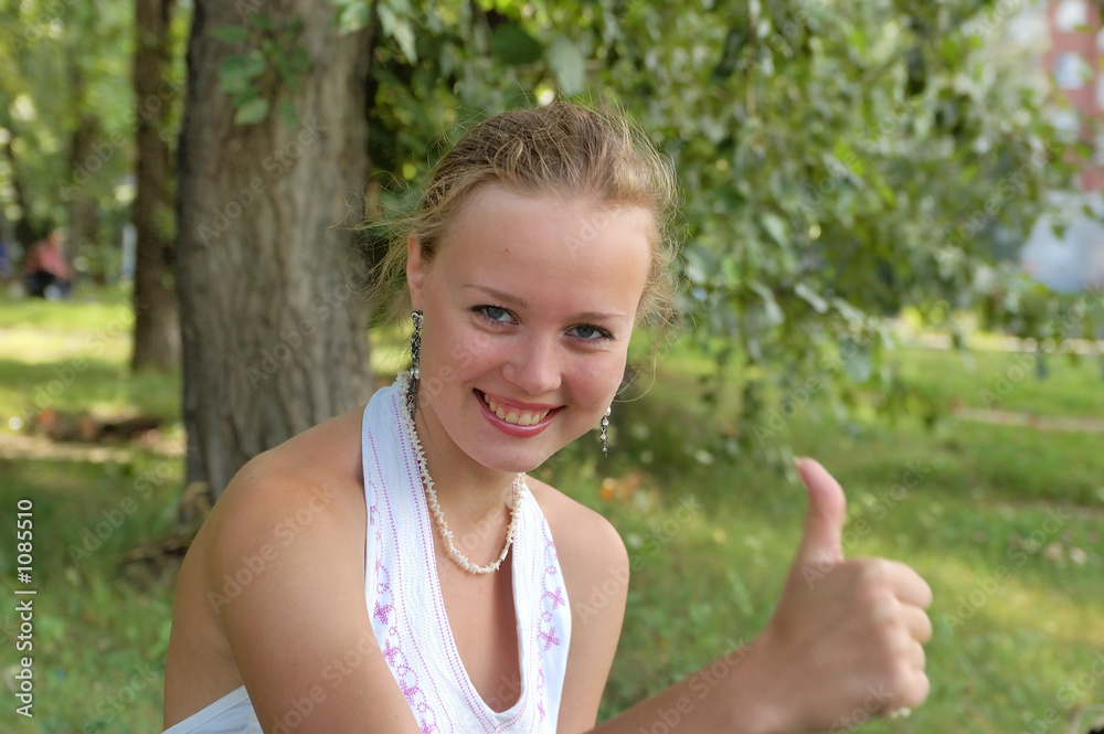 beautiful girl sitting on a park with thumb up beautiful girl sitting on a park with thumb up