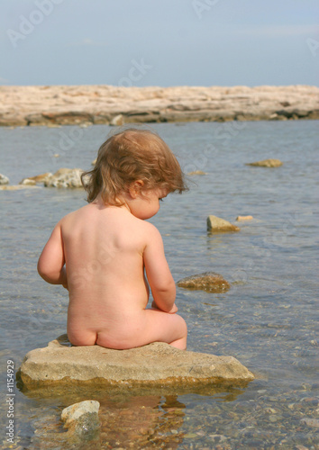 Petit enfant nu assis au bord de mer Stock Photo | Adobe Stock