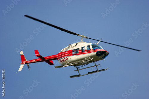 helicopter flying against a deep blue sky