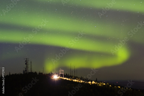 aurora borealis over hill with antennas and car wi