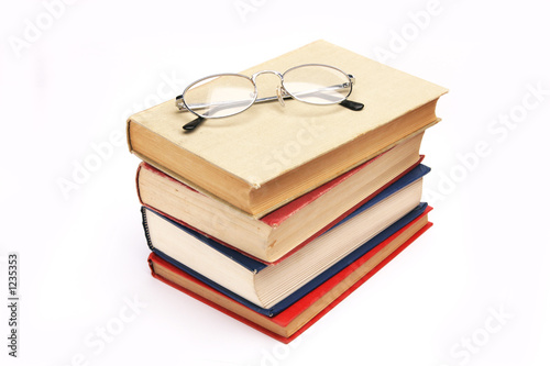 pile of books with glasses
