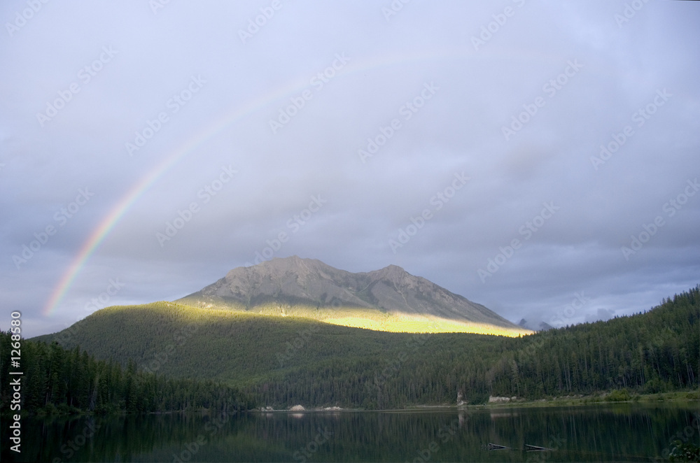 rainbow over the alces lake in the break of dawn