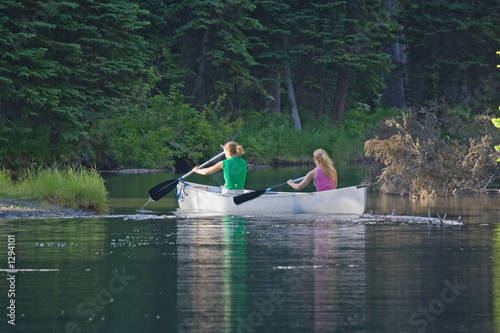 Fototapeta two women canoeing on a lake