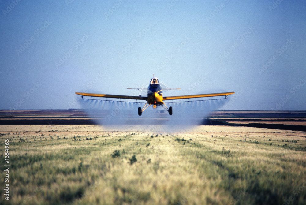 Naklejka premium spray plane spraying barley field in colorado