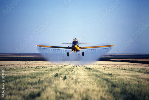 spray plane spraying barley field in colorado