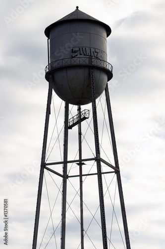 abandoned water tower against cloudy sky