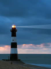 Poster Vuurtoren Vuurtoren in avondschemering aan zee  © MikLav