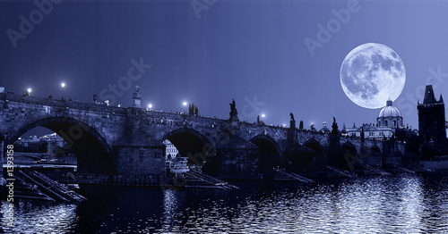 Photo huge moon over charle's bridge in prague