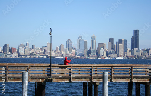 fisherman on pier with seattle skyline