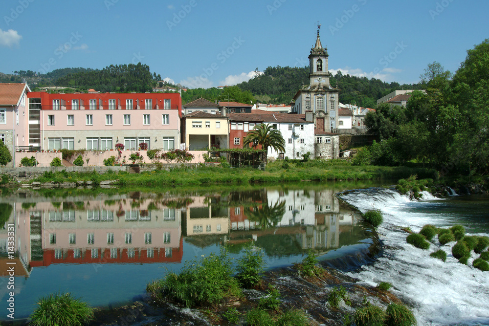 village reflected in the river with cascade