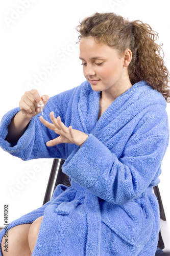 young woman dressed blue bathrobe painting nails