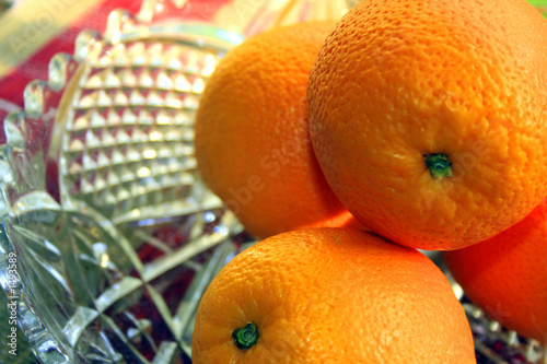 4 oranges in a glass fruit bowl
