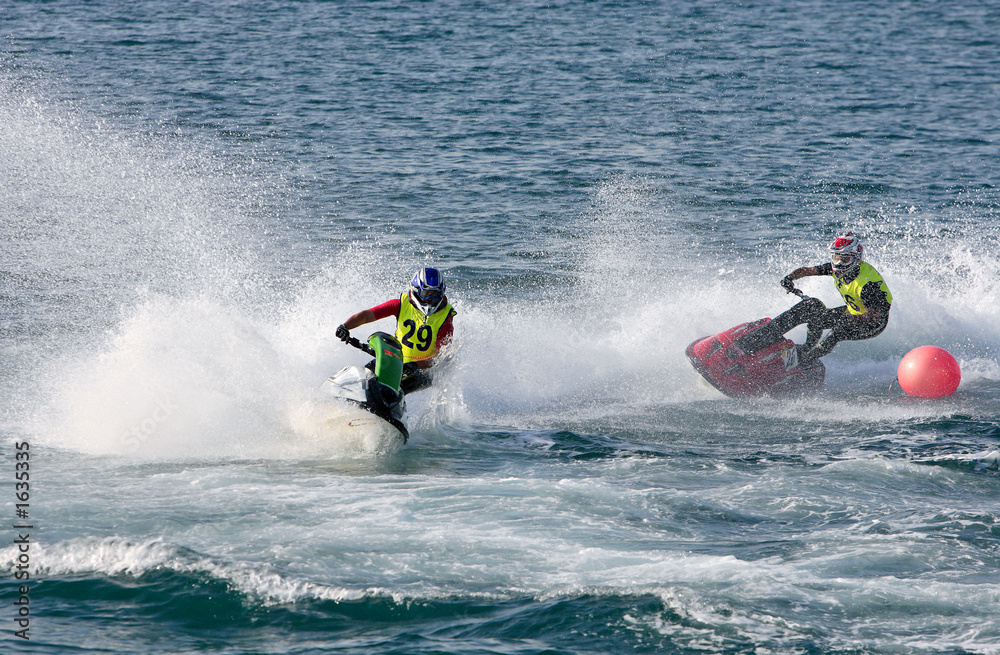 two young men speeding along on jetbike during a race two young men speeding along on jetbike during a race