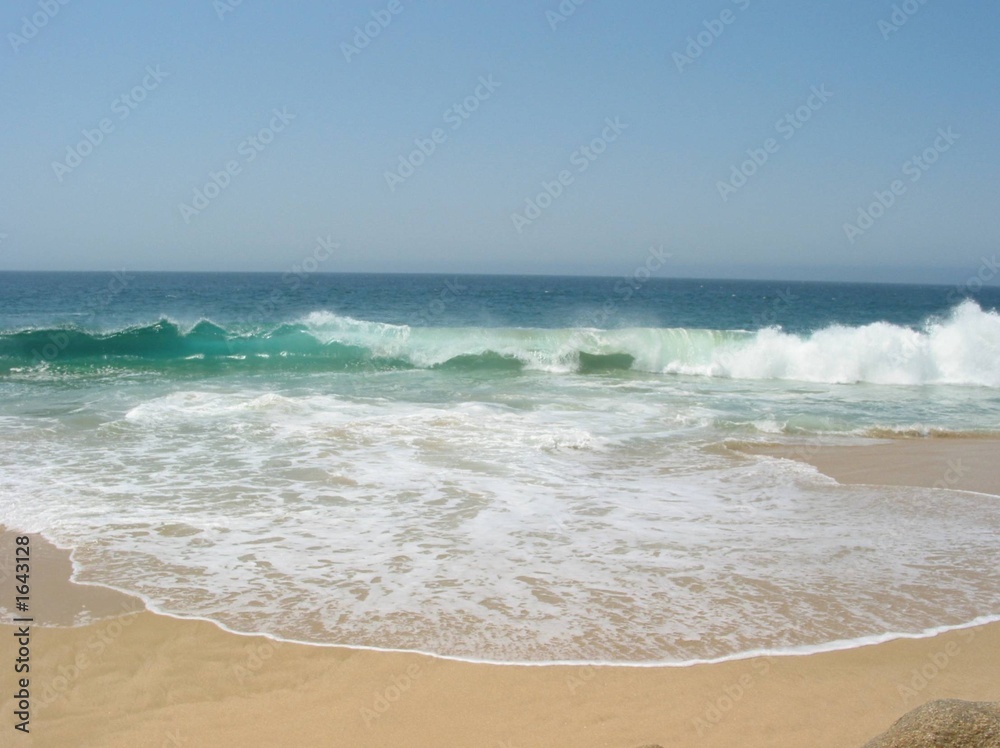 White Waves from Turquoise Ocean Water Crashing on the Sandy Beach