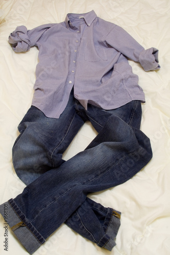 man's shirt and jeans on white bed