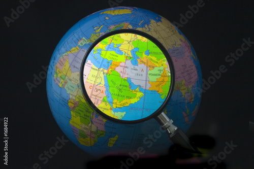 Map of middle east on globe seen through magnifying glass