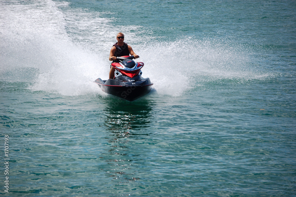 man on a red whtie and blue jet ski