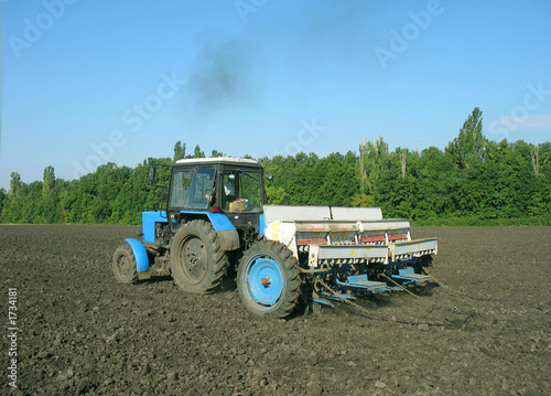  the tractor processes the ground under crop.