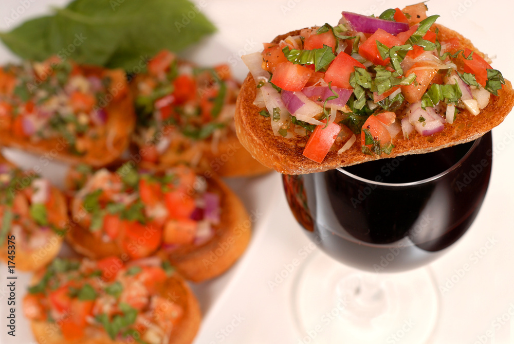bruschetta resting on a glass of wine with additional bruschetta bruschetta resting on a glass of wine with additional bruschetta