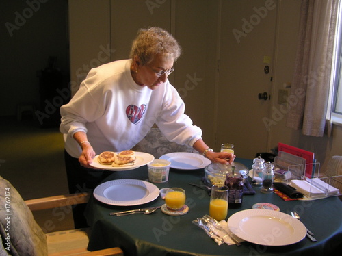 senior female serving breakfast