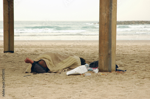 homeless person sleeping on beach