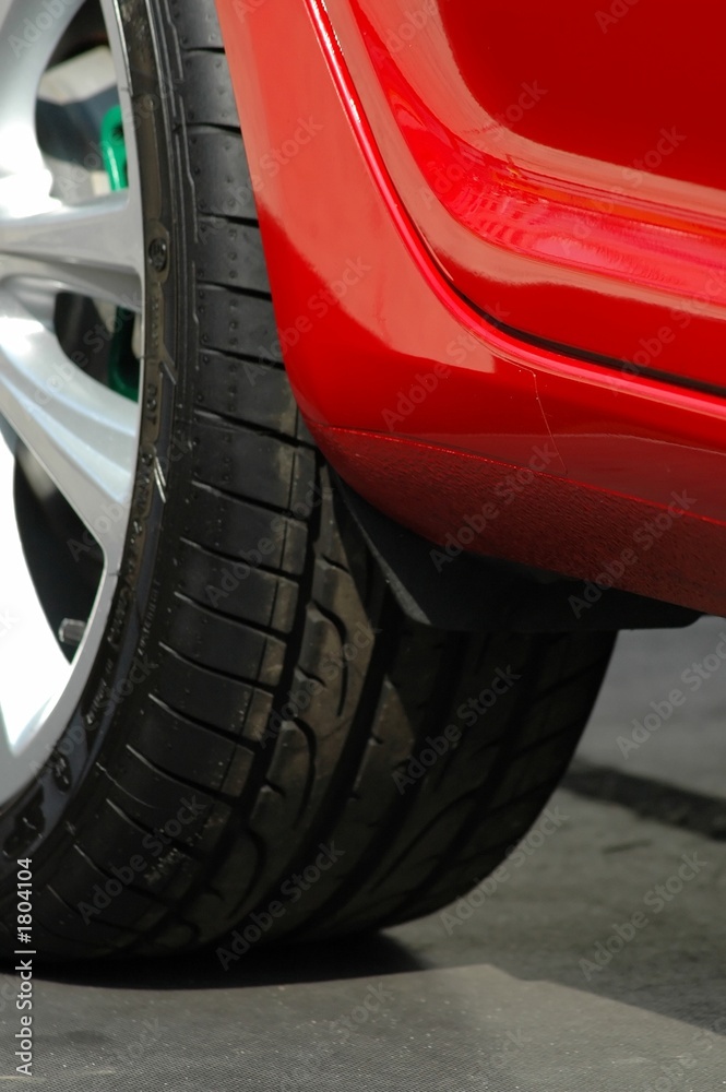 black tyre of a red car closeup - focus on car