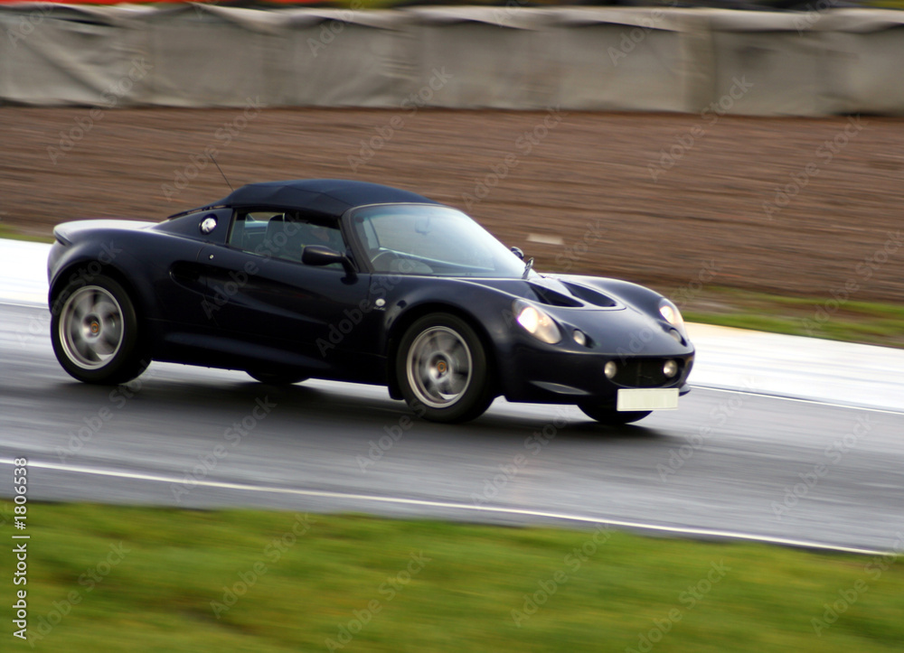 dark blue sports car on wet racing circuit