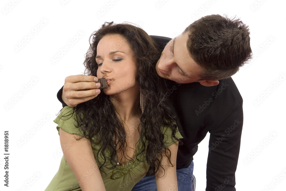 young couple feeding each other chocolate young couple feeding each other chocolate