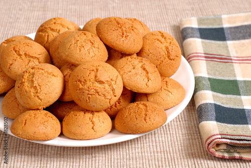 plate of crisp italian amaretti cookies with a checkered napkin