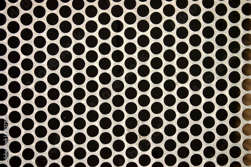 close up of a metal fence with round holes