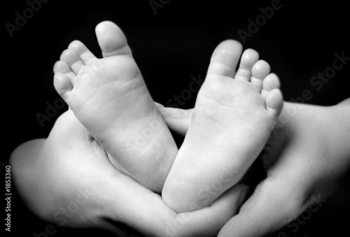 mother's hands holdning hers son's feet photo