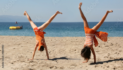 two girls doing cartwheel photo