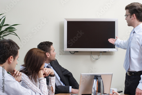 man making presentation on plasma screen to the gr