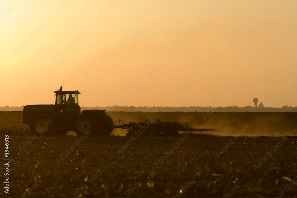Fototapeta premium silhouette of farmer tilling his land after the ha
