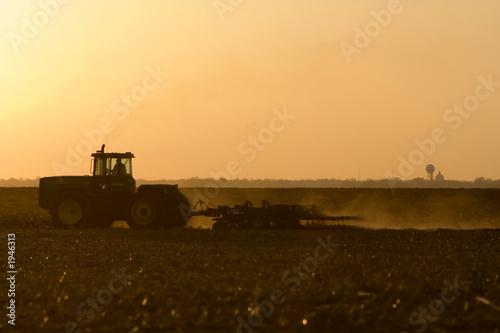 silhouette of farmer tilling his land after the ha