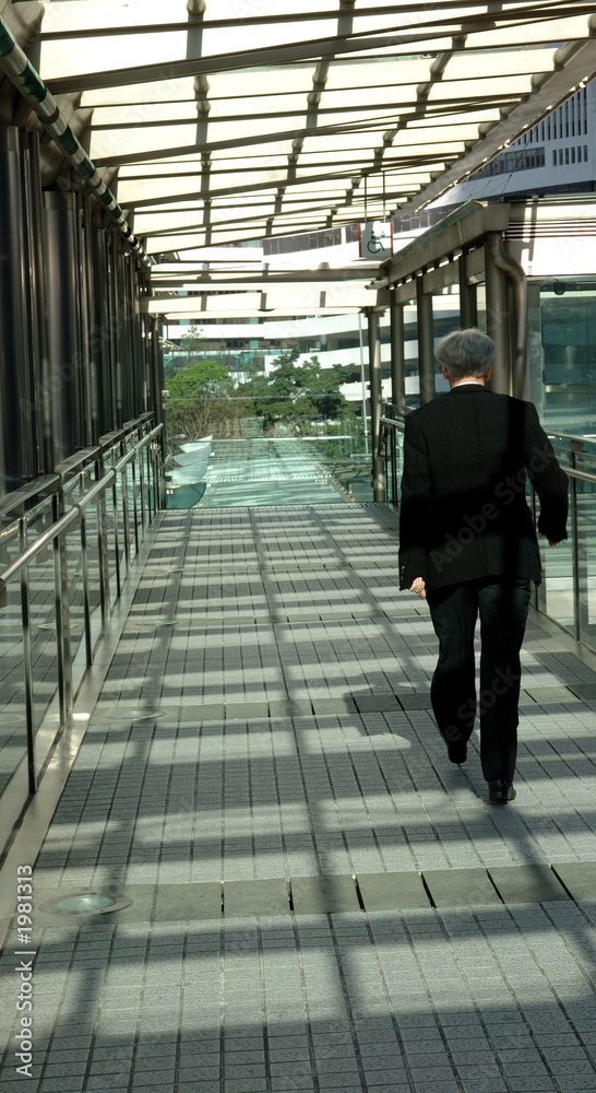 businessman walking on modern bridge businessman walking on modern bridge