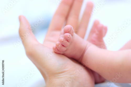 man hold baby leg in hand