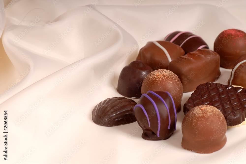Fototapeta premium pieces of semi-sweet and bittersweet chocolate on beige satin