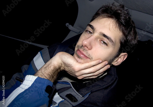 jeune homme fatigué et souriant en voiture photo