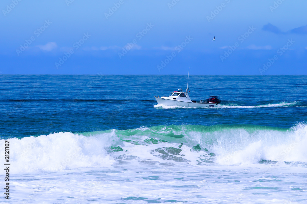 Fototapeta premium fishing boat trawling for fish and checking lobster traps