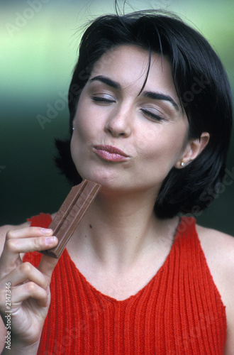 ragazza mangia barretta di cioccolata photo