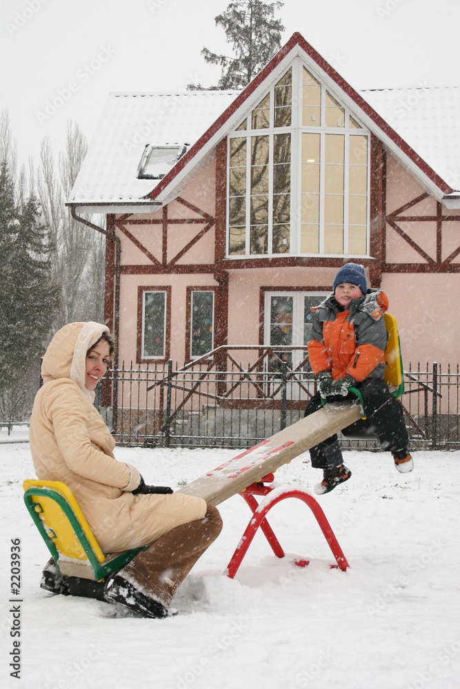 mother with son on winter seesaw mother with son on winter seesaw