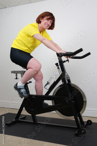 woman working out indoors on a spinning bike