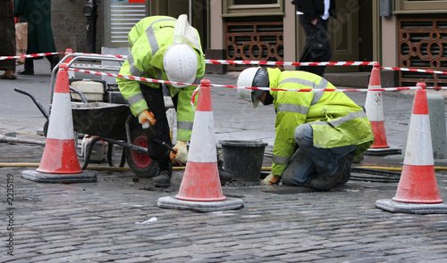 two workman repairing pavement