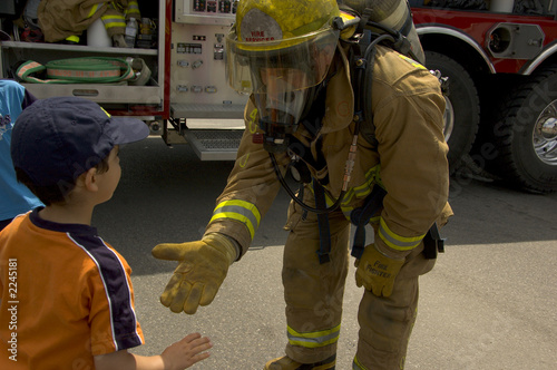 Fototapeta firefighter in uniform with a child