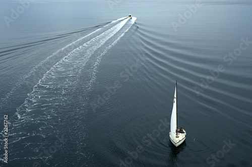One sail boat and one yacht heading in different direction. Beautiful ripples in the water.