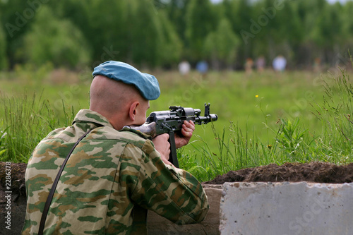 soldier in camouflage uniform with kalashnikov is