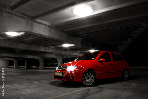 red hatchback car on black and white background photo